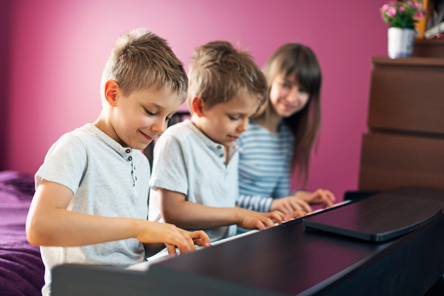 Three kids playing piano together